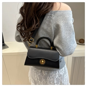 Detailed view of a black vintage matte leather crossbody bag with a gold round lock