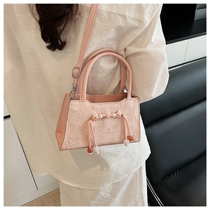 Pink peach blossom bucket bag with lace embroidery and pearl tassels shown on model