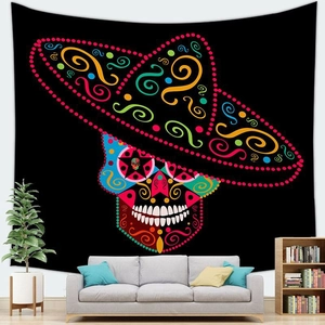 Halloween Mexican sugar skull tapestry hanging on a white wall above a grey sofa