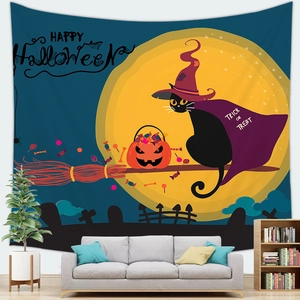 Halloween tapestry with black cat and pumpkin lanterns above a gray sofa in a living room