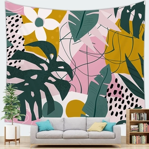 Tapisserie de feuilles tropicales artistiques accrochée au mur sur un canapé gris