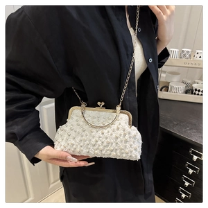 Détail de pochette coquillage blanche avec perles, fleurs 3D et fermoir doré chic