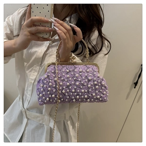 Détail de roses en tissu violet et perles blanches sur sac à main avec chaîne dorée