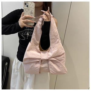Gros plan du sac fourre-tout rose en forme de nœud avec tissu en nylon froissé