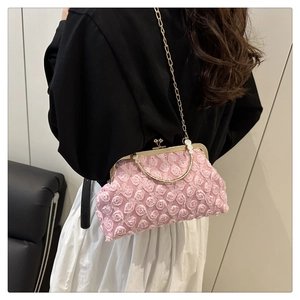 Close-up of pink 3D rose textured shell bag with gold chain strap and metal ball clasp