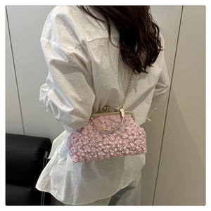 Détail du sac de soirée rose avec perles, fleurs en relief et poignée dorée en métal