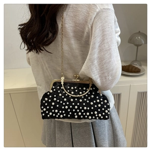 Detailed view of elegant black lace pearl clutch bag with gold frame and chain strap