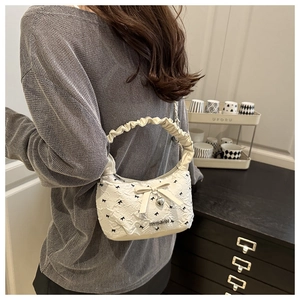 Detail of white seersucker bag with black bow prints and heart pendant decoration