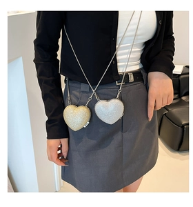 Dettaglio delle mini borse a cuore con glitter e catene metalliche in oro e argento