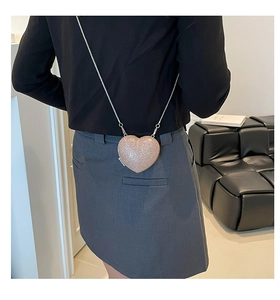 Dettaglio borsa a cuore glitterata con sottile tracolla a catena in argento