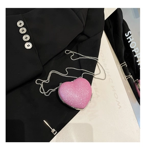 Dettaglio mini borsa cuore rosa con paillettes, tracolla a catena argento e bordi in metallo