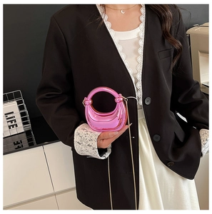 Detalle de mini bolso luna rosa metalizado con cadena dorada y asa circular brillante