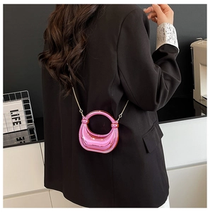 Detail of trendy metallic pink acrylic crossbody bag with a golden chain and mini handle