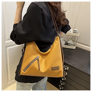 Detail of yellow chevron tote bag with zipper pocket and leather fashion tag