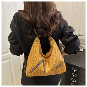 Detalle del bolso tote amarillo con tejido de espiga, cremallera lateral y etiqueta