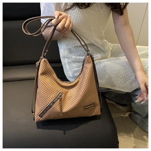 Close-up of brown woven Hobo bag showing textured herringbone pattern and zipper detail