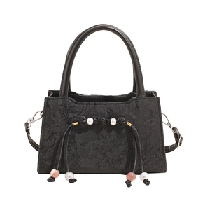 Elegant black embroidered crossbody bag with decorative bead charms and top handle