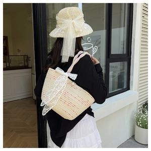 Detail of summer straw bag and hat set with elegant white lace bows and pearls