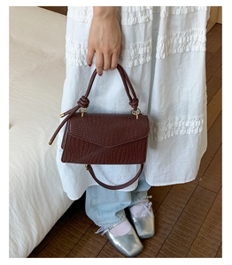 Vue détaillée du sac à main marron foncé en cuir texturé avec poignée nouée chic