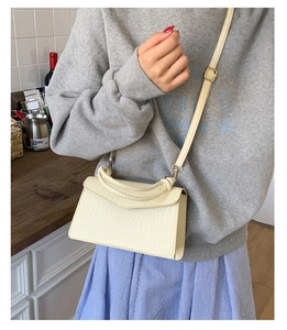 Détail du petit sac carré crème avec texture tressée, poignée nouée et bandoulière