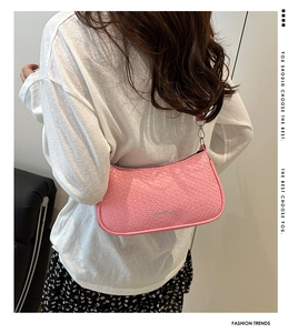 Detailed close-up of pink crescent underarm bag with textured leather and silver zipper