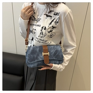 Gros plan du sac baguette rétro avec texture denim et boucle en métal doré élégante