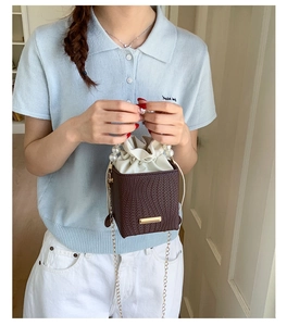 Detail showing high-capacity mini square bag with pearl handle and metal chain strap