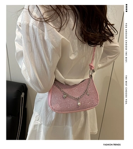 Vue arrière du sac à paillettes rose porté épaule avec des breloques argentées et perles