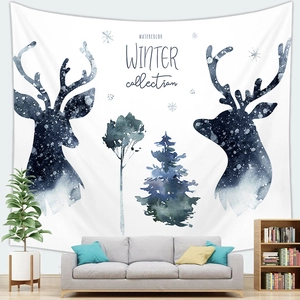 Watercolor winter tapestry with reindeer and pine trees hung over a modern sofa