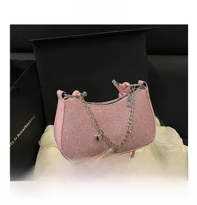 Gros plan du sac rose pailleté avec chaîne argentée, breloques cœur et perles