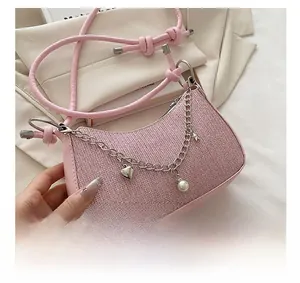 Détail du sac croissant rose à paillettes avec breloques cœur et perles sur chaîne