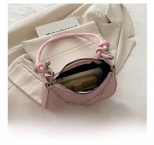 Sac sous le bras tissé rose montrant la capacité pour smartphone et petit portefeuille