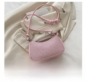 Détail du sac sous l'aisselle à paillettes roses montrant la comparaison avec un smartphone