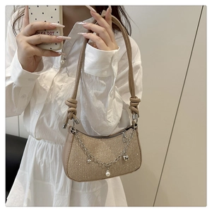 Détail du sac bandoulière pailleté avec charms étoiles argentées et pendentifs perles