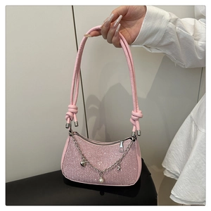Détail d'un sac à paillettes rose avec charms cœur et étoile sur une chaîne argentée