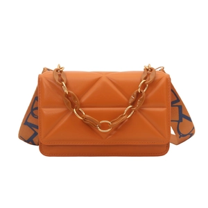 Orange quilted crossbody bag with textured triangle pattern and woven shoulder strap