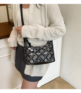 Detail of traditional pattern embroidery on the shoulder bag with bead zipper pullers