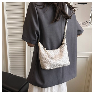 Detailed close-up of textured geometric jacquard pattern and beaded zipper on tote bag