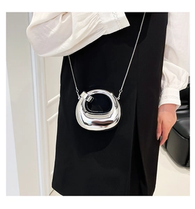 Detail of mirror silver mini acrylic bag featuring chic metallic texture and chain strap