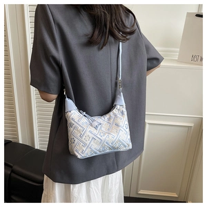 Detail of blue ethnic embroidery pattern and drawstring on hobo shoulder bag