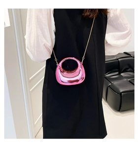Close-up of pink mirror acrylic crescent bag with golden chain and curved handle