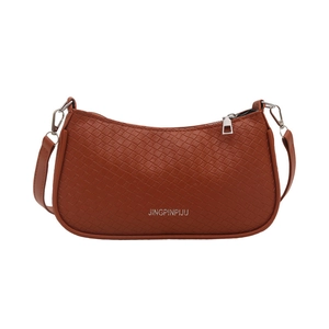 Brown woven texture baguette bag with silver zipper and shoulder strap on white background