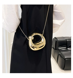 Close-up of a stylish gold metal hollow ring evening bag with a sleek chain strap