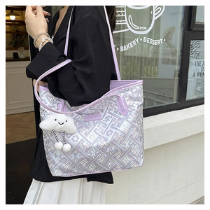 Dettaglio borsa tote jacquard viola con cinturino in pelle e ciondolo a forma di nuvola
