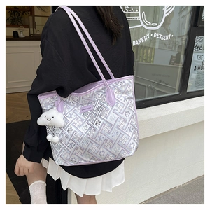 Dettaglio della borsa tote jacquard lavanda con motivo geometrico e ciondolo a nuvola