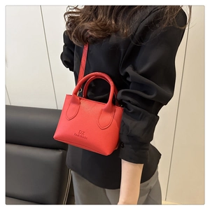 Detail of red mini lychee leather crossbody bag with dual handles and brand logo