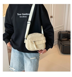 Détail du sac bandoulière en velours côtelé blanc cassé avec large sangle réglable