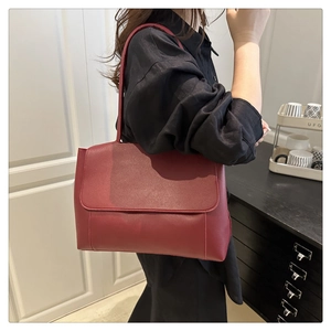 Detail of burgundy PU leather tote bag with flap closure and adjustable shoulder strap