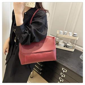 Detail of red matte leather tote bag with shoulder strap and sleek rectangular flap design