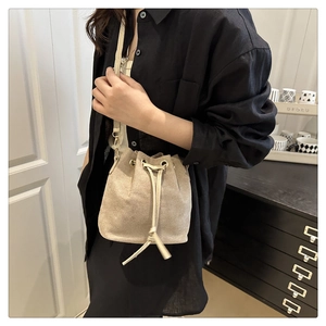 Détail du sac seau champagne en tissu perlé avec cordon de serrage doré élégant